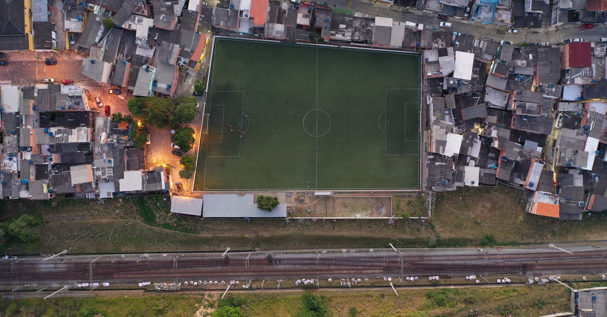 What is a good outskirts area to stay in Washington DC [closed] - Aerial view of football field surrounded by small typical residential houses in city outskirts near road