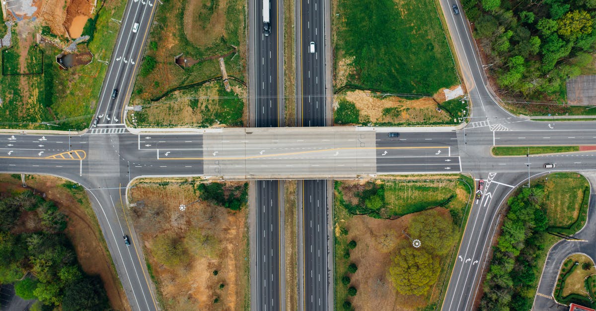 What is a safe and scenic way to drive from Barcelona to Madrid? [closed] - Highway junction with marking lines near green trees in suburb
