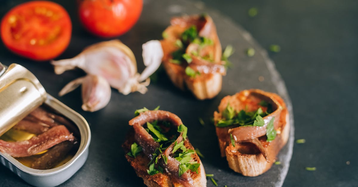 What is a typical Australian dish which can be considered a "must-have"? [closed] - Photo of a Can of Anchovies Near Bread