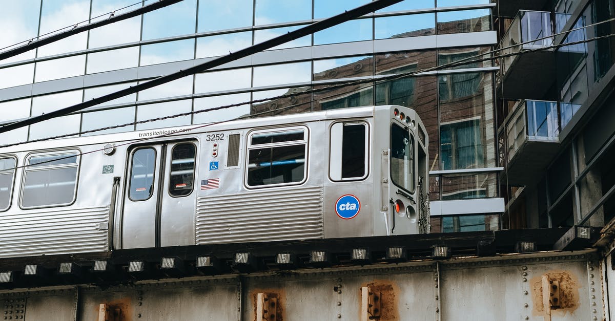 What is considered impolite in Central/South American area - Aged metal gray train driving on bridge near contemporary glass building in daytime
