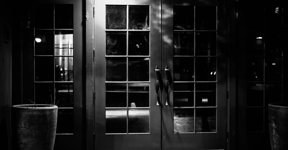 What is fair compensation for being thrown out of hotel late at night for no lawful reason? [closed] - Black and white of entrance with closed glass door of empty bar at night
