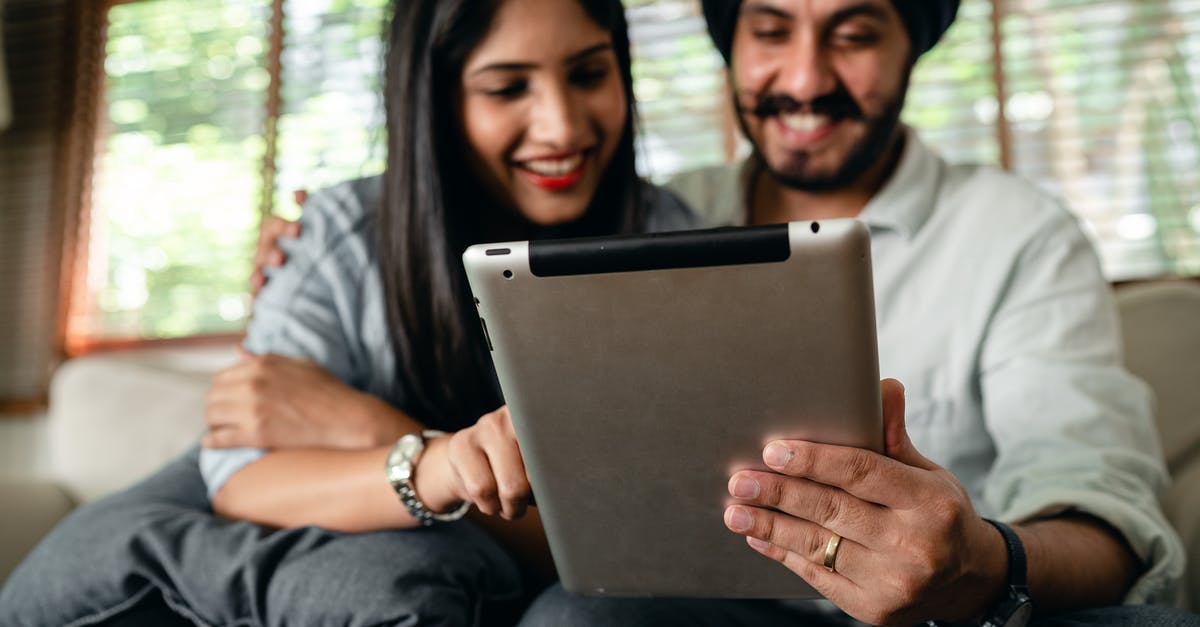 What is the actual fee for getting an Indian e-Visa online from government portal? - Joyful young Indian couple watching video on tablet and having fun What is the actual fee for getting an Indian e-Visa online from government portal? - Joyful young Indian couple watching video on tablet and having fun