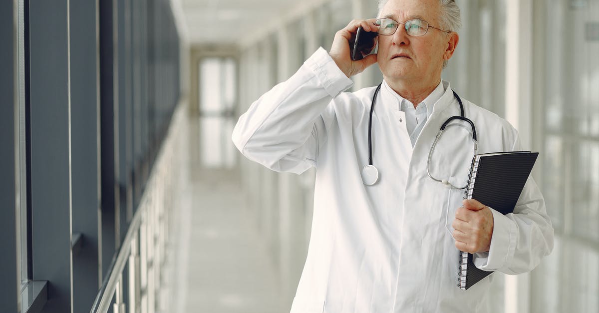 What is the best assistance or help that I can arrange for elderly parents who don't speak English? - Serious mature male doctor in medical uniform standing with stethoscope and notebook while talking on smartphone in clinic corridor