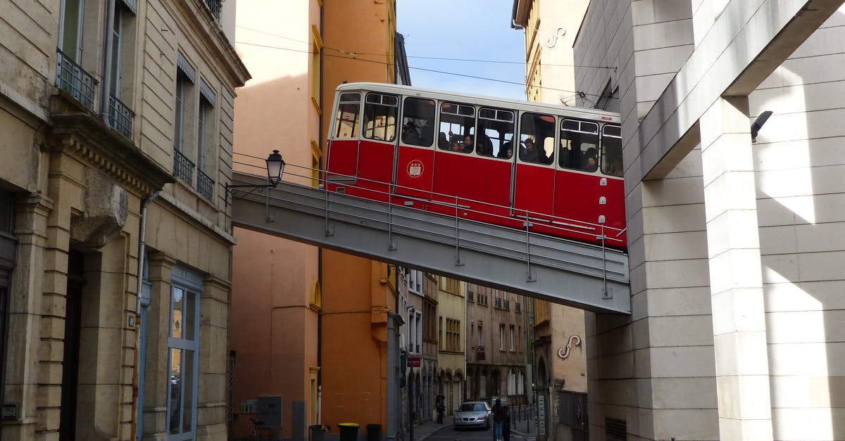 What is the cheapest way to go from Poland to Lyon (France)? [closed] - Aged red cable car driving in old district of Lyon between shabby buildings on sunny day