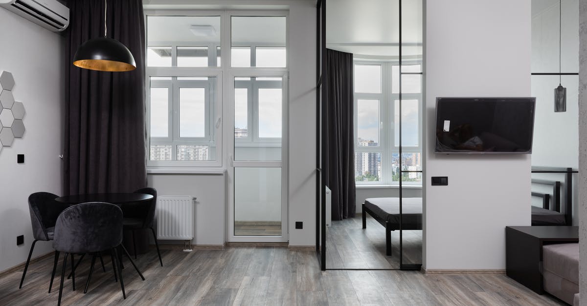 What is the Difference Between Air Conditioning and Climate Control? - Contemporary room interior with chairs under lamp and air conditioning in light house with glass wall What is the Difference Between Air Conditioning and Climate Control? - Contemporary room interior with chairs under lamp and air conditioning in light house with glass wall