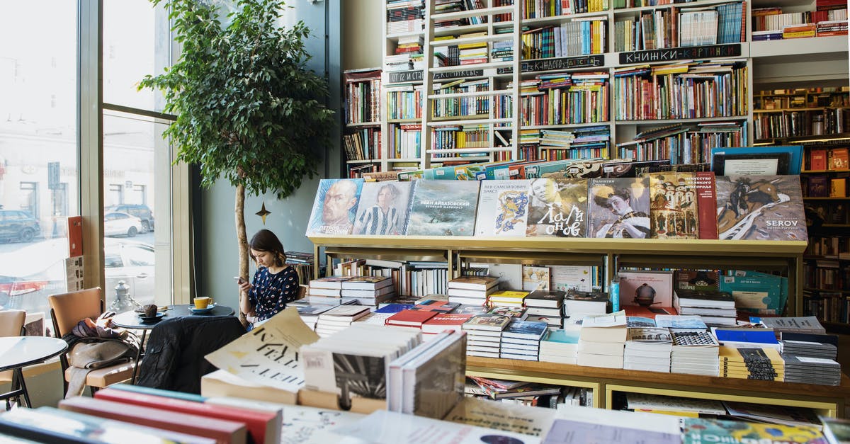 What is the difference between customs and immigration? - Young female client in casual wear chatting on cellphone while sitting at table with cup of hot drink in cozy bookstore in afternoon What is the difference between customs and immigration? - Young female client in casual wear chatting on cellphone while sitting at table with cup of hot drink in cozy bookstore in afternoon