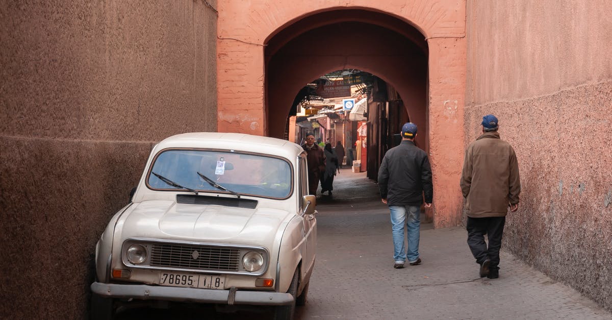 What is the easiest way to travel between western Europe and Morocco without using plane? [closed] - Unrecognizable men walking on street near arched passage