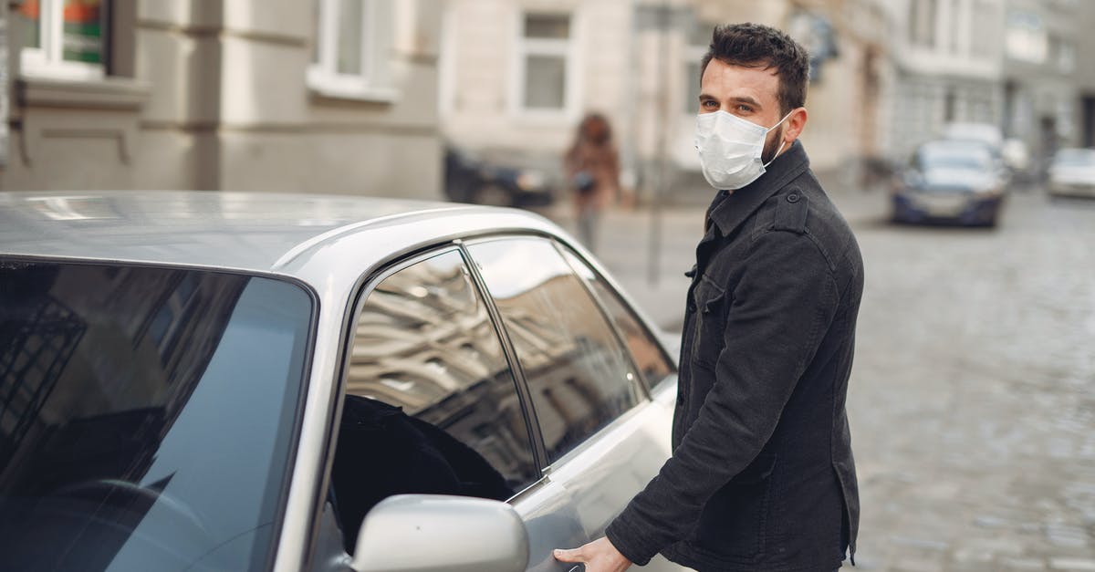What is the highest pass in the world that is kept open (plowed) in winter? - Bearded male driver wearing warm jacket and protective facial mask opening door of auto on blurred city background during Coronavirus pandemic and looking at camera What is the highest pass in the world that is kept open (plowed) in winter? - Bearded male driver wearing warm jacket and protective facial mask opening door of auto on blurred city background during Coronavirus pandemic and looking at camera