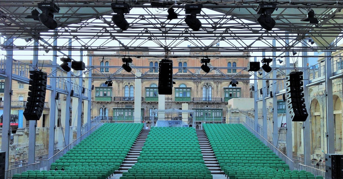 What is the location of this performance? - Outdoor auditorium and stage with professional equipment on city square What is the location of this performance? - Outdoor auditorium and stage with professional equipment on city square