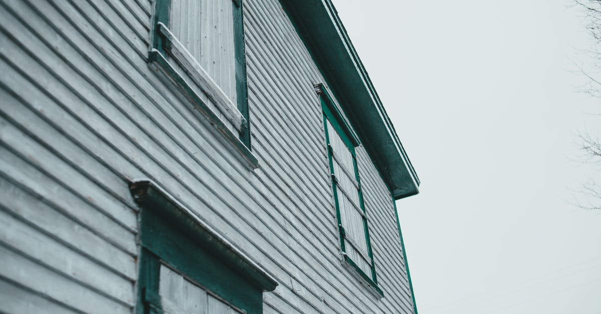 What is the purpose of this wooden rectangular arch shaped construct in Siberia? - Low angle of aged building exterior with painted wooden wall and shutters under light sky in town What is the purpose of this wooden rectangular arch shaped construct in Siberia? - Low angle of aged building exterior with painted wooden wall and shutters under light sky in town