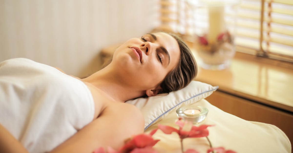 What is the reason for differential treatment between foreign and local customers at Sukiyabashi Jiro? [closed] - Woman in Wrapped in White Towel Lying on Bed with Eyes Closed