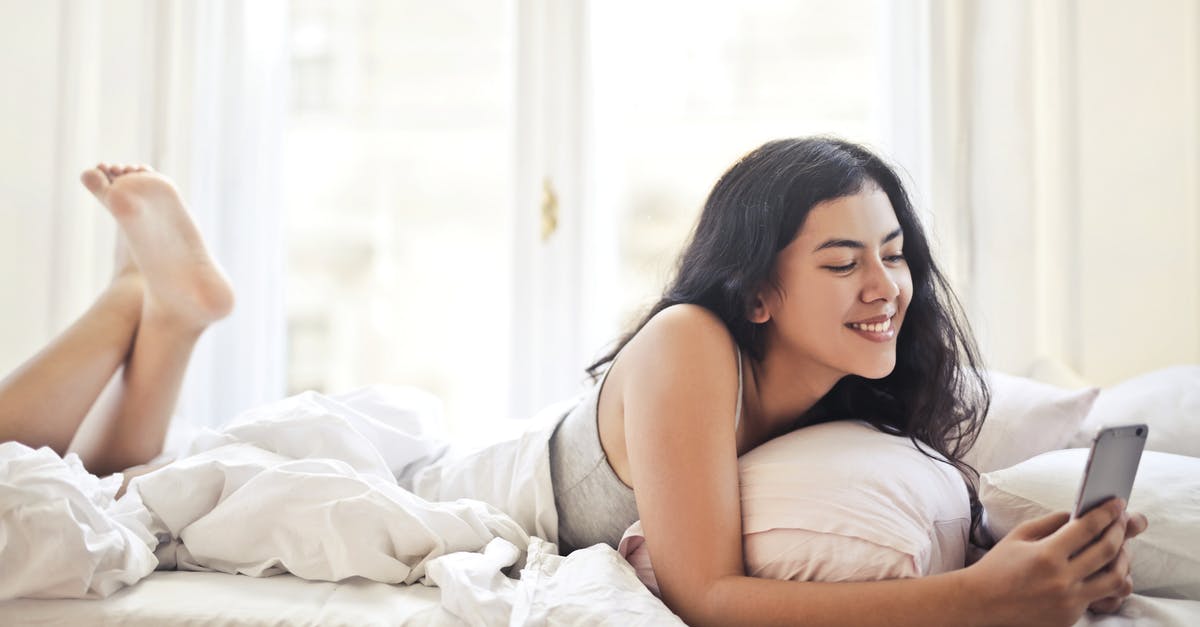 What is the time limit for using T-Mobile SIM cards in Canada? - Happy young woman browsing phone on bed What is the time limit for using T-Mobile SIM cards in Canada? - Happy young woman browsing phone on bed
