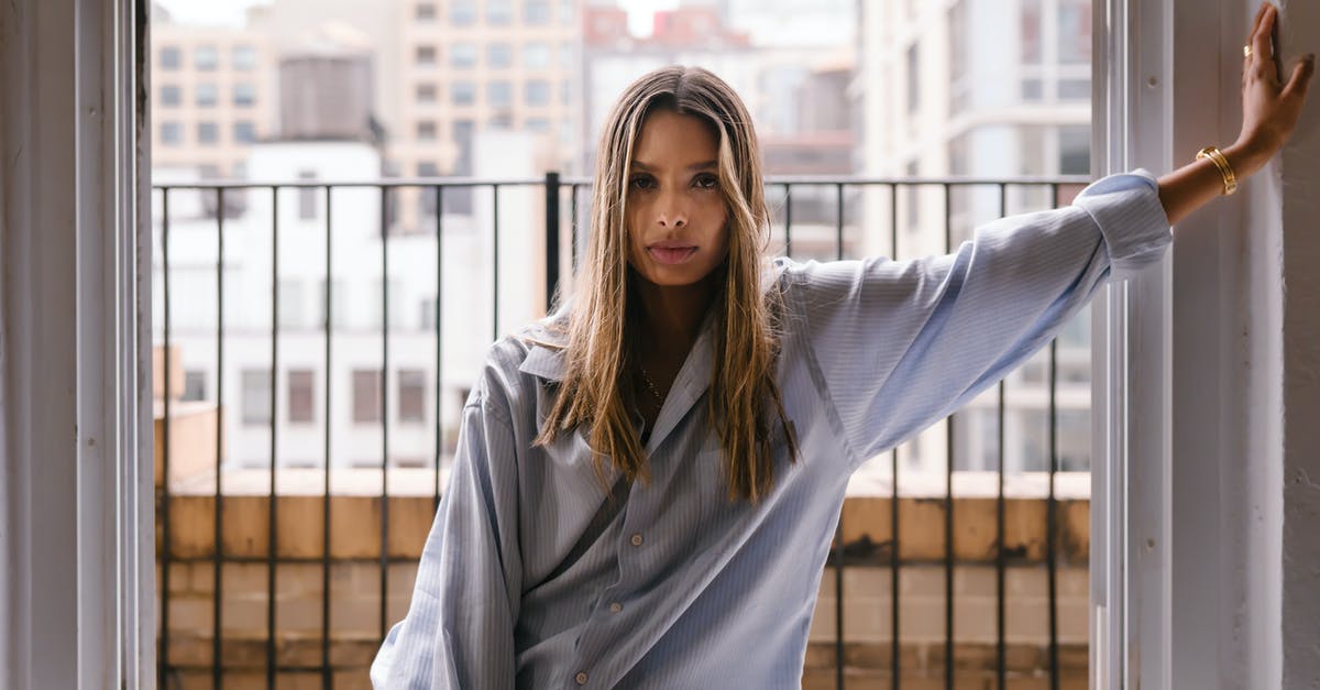 What is this building? - Woman in Gray Long Sleeve Shirt Standing Beside Window What is this building? - Woman in Gray Long Sleeve Shirt Standing Beside Window