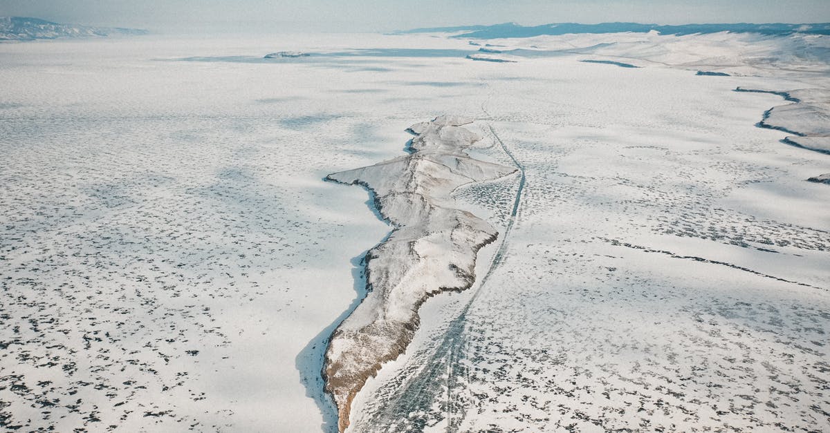 What is this formation on sea, seen from the air? - Drone view of rocky formation on icy ocean with snow under cloudy sky in wintertime What is this formation on sea, seen from the air? - Drone view of rocky formation on icy ocean with snow under cloudy sky in wintertime