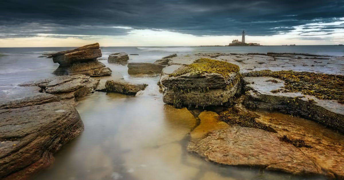 What is this formation on sea, seen from the air? - From above of rough cliffs near ocean water with horizon under cloudy sky in evening What is this formation on sea, seen from the air? - From above of rough cliffs near ocean water with horizon under cloudy sky in evening