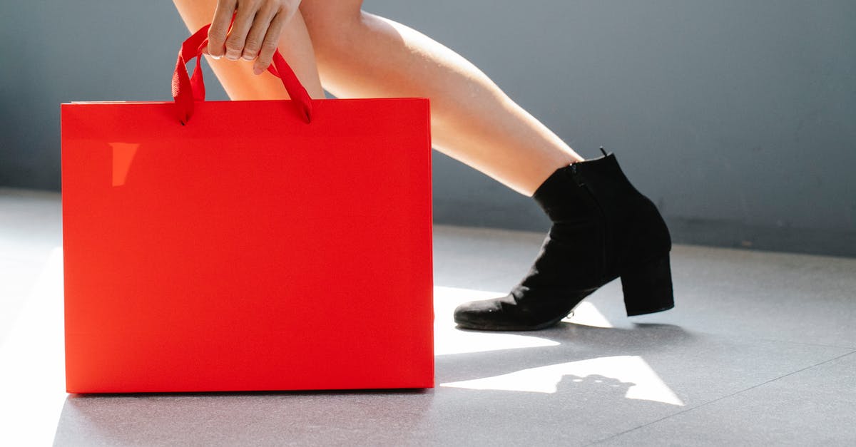 What is this "nekoya" shop advertising? - Side view of crop unrecognizable female in trendy boots holding red paper bag while standing on street on sunny day after shopping What is this "nekoya" shop advertising? - Side view of crop unrecognizable female in trendy boots holding red paper bag while standing on street on sunny day after shopping
