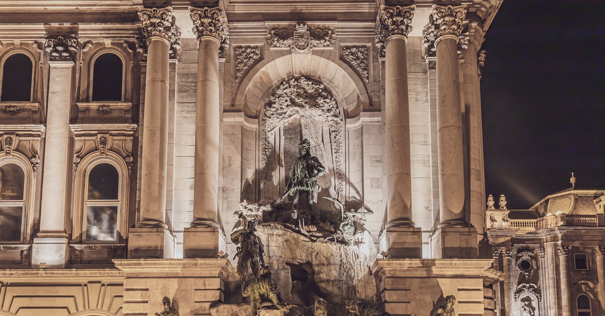 What is this statue about in the throne room Royal Palace Madrid? - Famous landmark of Budapest aged Matthias Fountain in courtyard of Buda Palace with group statues at night What is this statue about in the throne room Royal Palace Madrid? - Famous landmark of Budapest aged Matthias Fountain in courtyard of Buda Palace with group statues at night