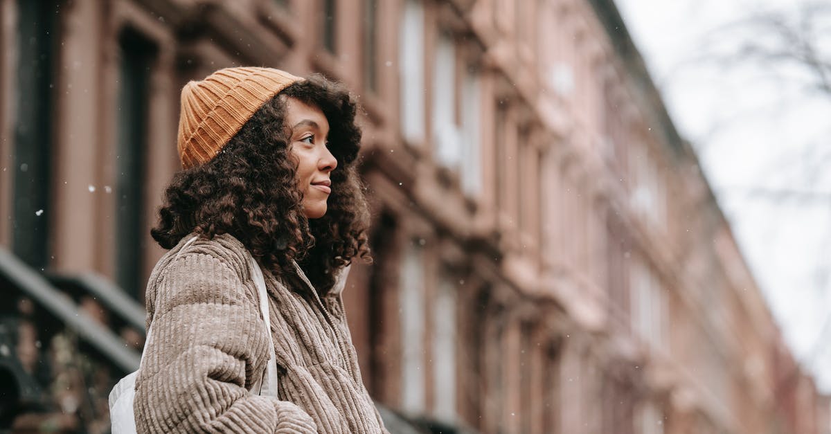 what kind of hat would be most effective for reducing heat? - Contemplative black woman on street in snowfall what kind of hat would be most effective for reducing heat? - Contemplative black woman on street in snowfall