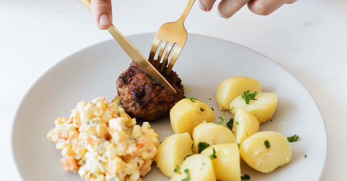 What meals are available on Russian trains? - From above of crop anonymous person cutting with cutleries fried juicy meat cutlet served on white plate with tasty boiled potatoes and Russian salad What meals are available on Russian trains? - From above of crop anonymous person cutting with cutleries fried juicy meat cutlet served on white plate with tasty boiled potatoes and Russian salad
