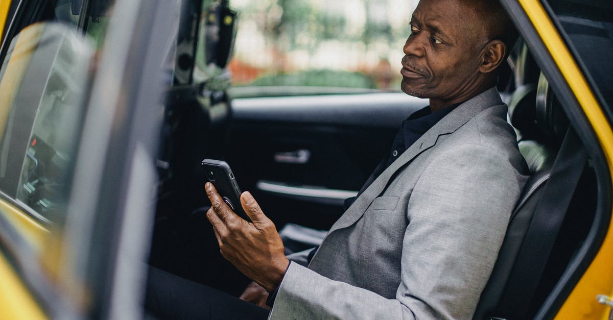 What mobile taxi app can I use in Kutaisi Georgia? - Contemplative black businessman using smartphone in taxi What mobile taxi app can I use in Kutaisi Georgia? - Contemplative black businessman using smartphone in taxi