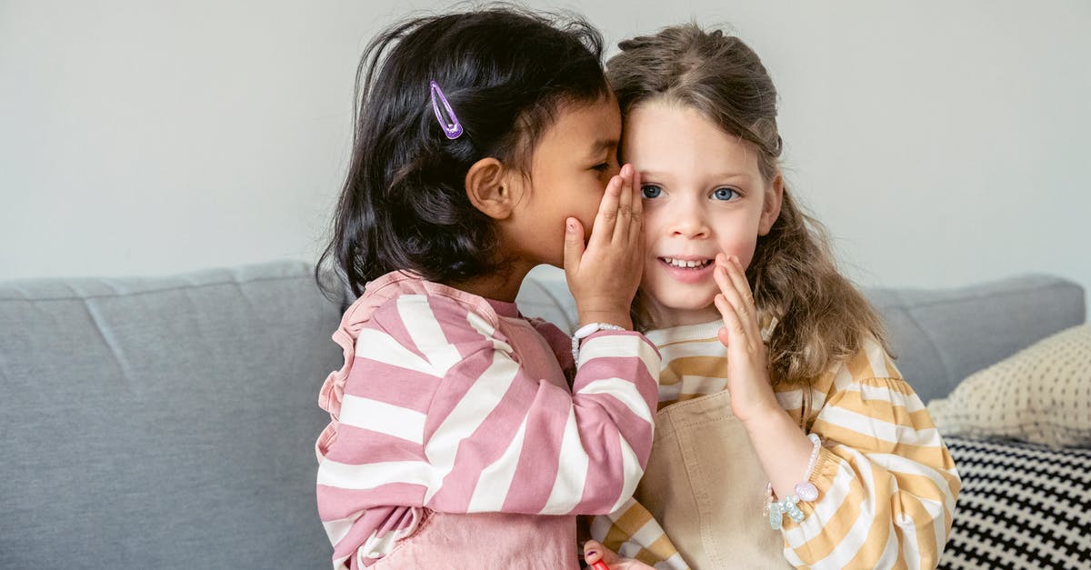 What should a sponsor tell the ECO? - Ethnic girl sitting on sofa close to smiling best friend and whispering secrets on ear What should a sponsor tell the ECO? - Ethnic girl sitting on sofa close to smiling best friend and whispering secrets on ear