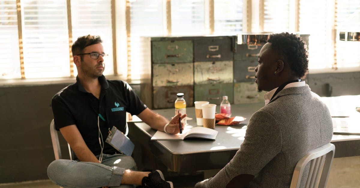 What should I be aware of when hiring a car from one of the cheaper rental firms in Spain? - Man Wearing Black Polo Shirt and Gray Pants Sitting on White Chair What should I be aware of when hiring a car from one of the cheaper rental firms in Spain? - Man Wearing Black Polo Shirt and Gray Pants Sitting on White Chair