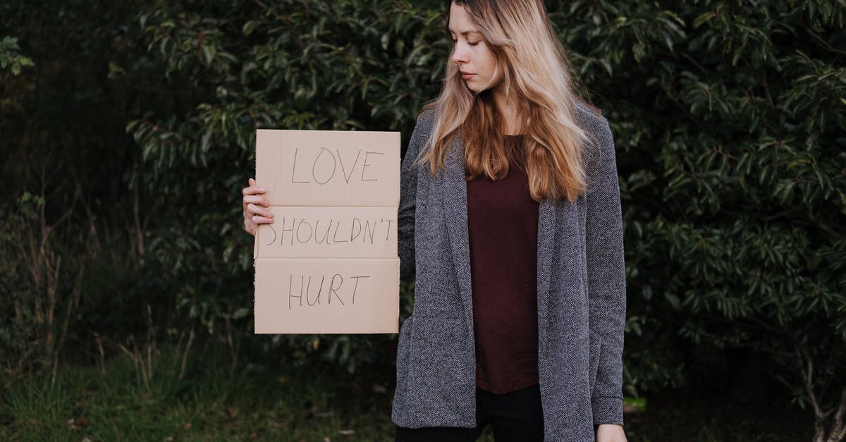 What should I do to avoid ear pain when flying? - Female demonstrating cardboard with words against abuse What should I do to avoid ear pain when flying? - Female demonstrating cardboard with words against abuse