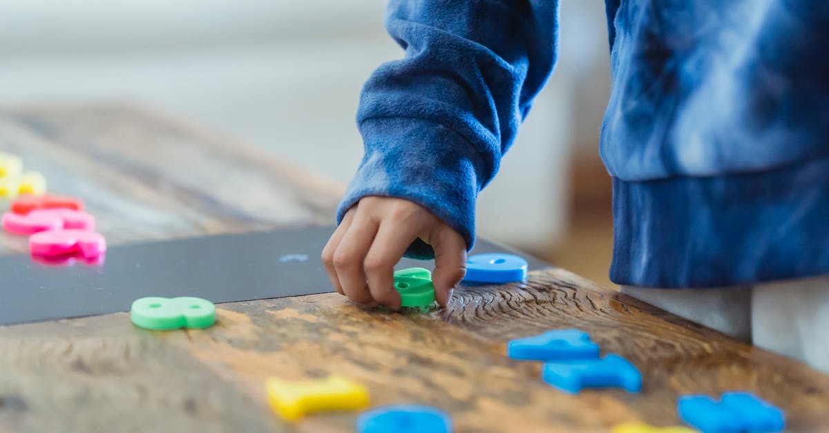 What should I think of and prepare when flying with kids? - Crop anonymous ethnic boy taking plastic number from wooden table while learning math What should I think of and prepare when flying with kids? - Crop anonymous ethnic boy taking plastic number from wooden table while learning math