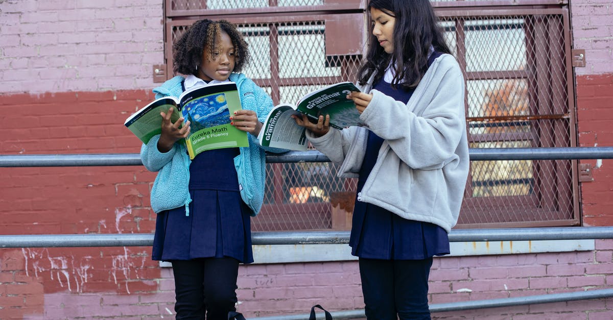 What should I think of and prepare when flying with kids? - Serious multiracial girls doing homework with textbooks near school What should I think of and prepare when flying with kids? - Serious multiracial girls doing homework with textbooks near school