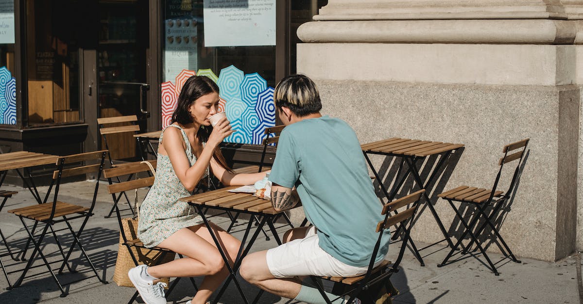 What should we plan to see on a weekend in Belfast? [closed] - Serious friends drinking coffee while sitting at table on street on sunny day in summer