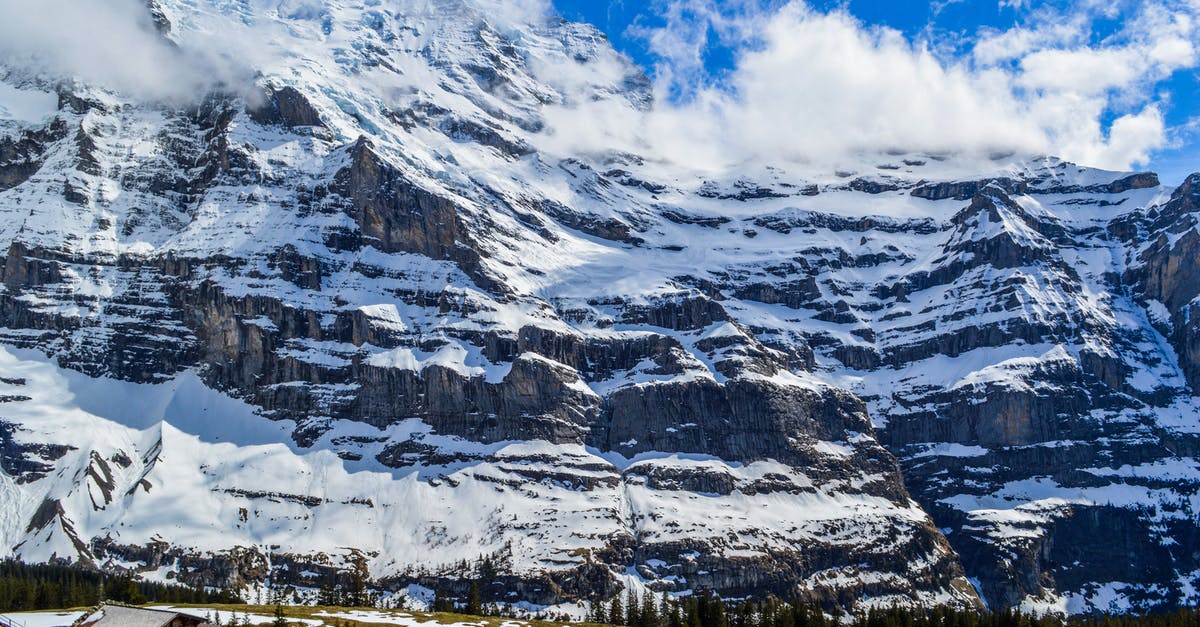 What sightseeing activities are available in winter in the Rocky Mountains? [closed] - Spectacular alpine landscape of small settlement located on grassy terrain near massive rocky mountain covered with snow in Switzerland
