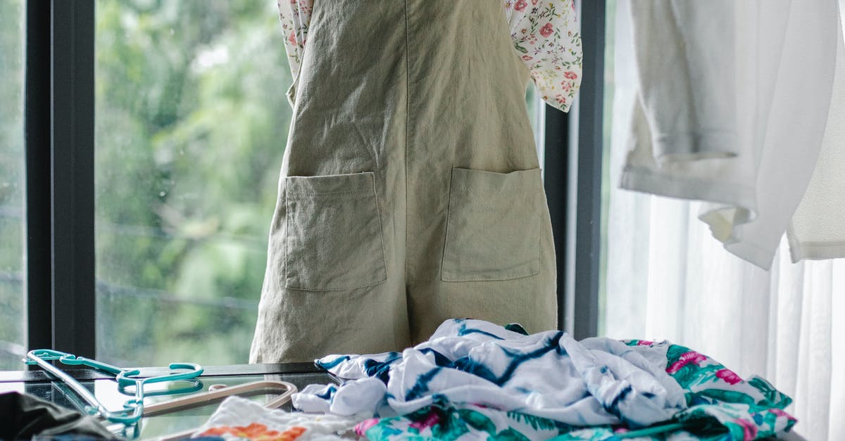 What sort of clothing should I pack for a trip to Geneva in early October [closed] - Crop faceless woman choosing outfit from clothes heap on table