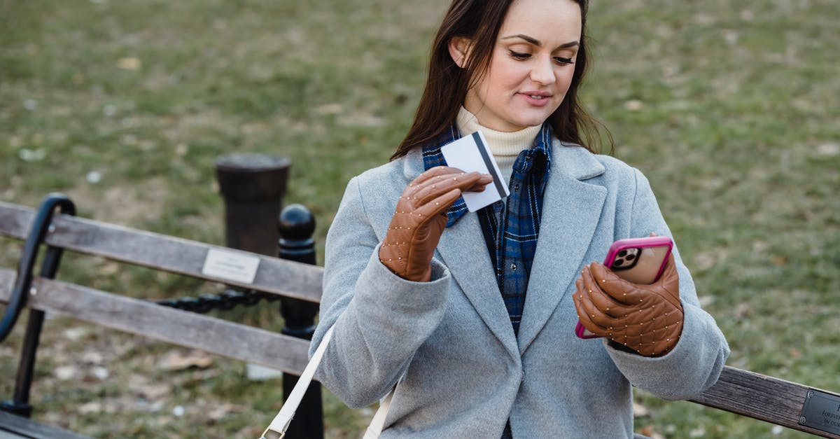 What to expect at a Global Entry application interview? - Glad woman making online payment via smartphone in spring park