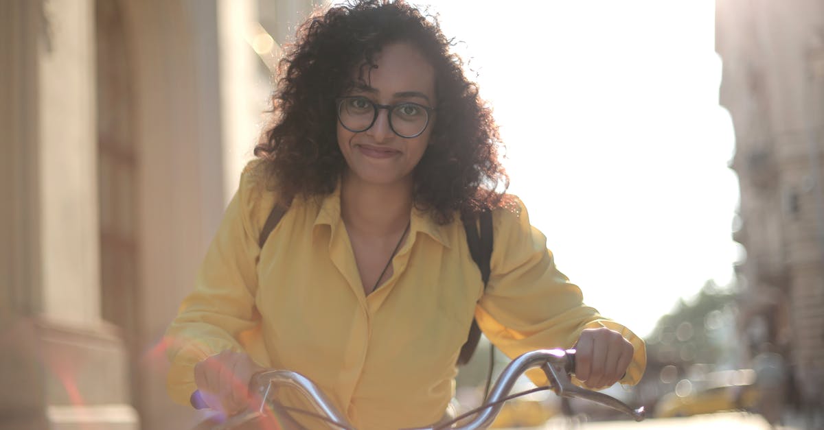 What to look for from insurance policies to cover a trip cancelled if my itinerary includes a city hit by the coronavirus? - From below cheerful young curly woman in glasses with backpack smiling at camera while riding bicycle along street in sunny day What to look for from insurance policies to cover a trip cancelled if my itinerary includes a city hit by the coronavirus? - From below cheerful young curly woman in glasses with backpack smiling at camera while riding bicycle along street in sunny day