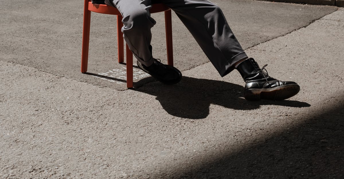 What to wear in Russia - Person in Black Pants and Black Shoes Sitting on Red Chair What to wear in Russia - Person in Black Pants and Black Shoes Sitting on Red Chair