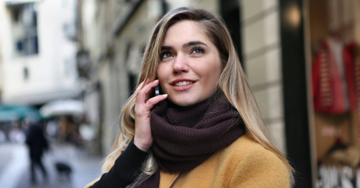 What trousers/pants do women wear in Baltic cities in winter? - Woman in Brown Scarf and Black Coat Looking Up The Sky