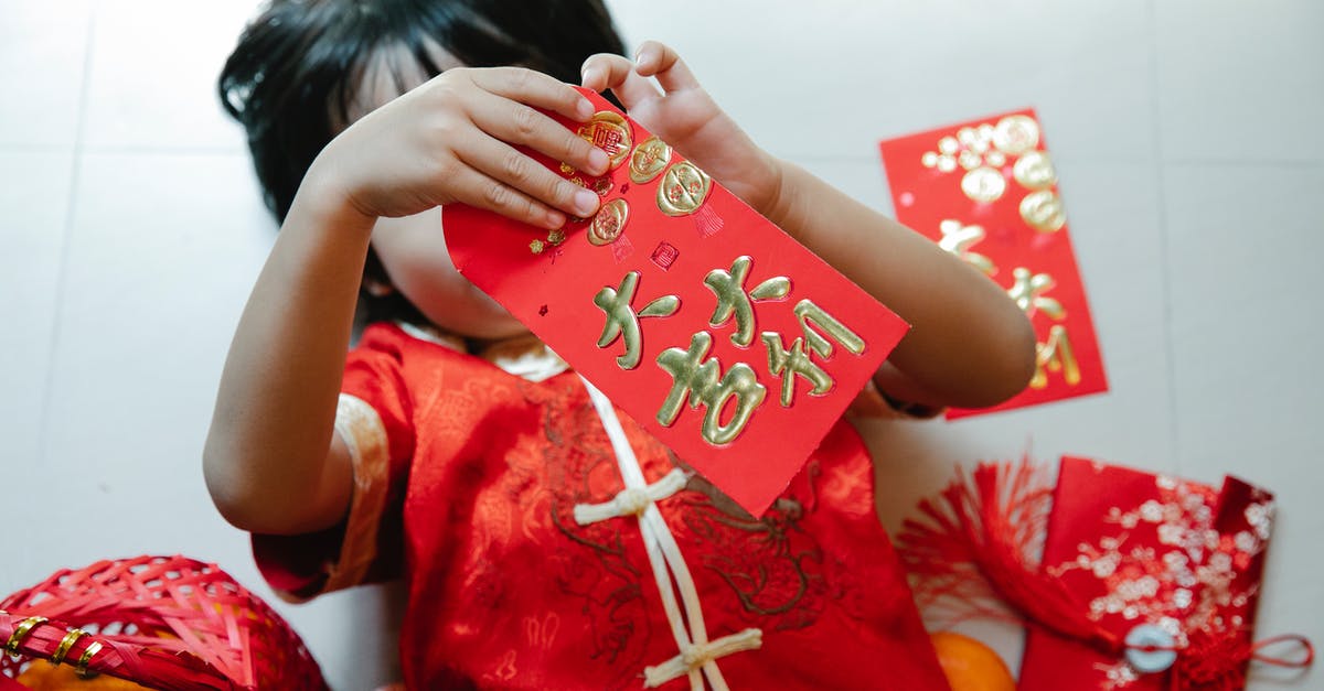 What type of Schengen visa should I apply for when to visit Switzerland for a two-day Open House event? - From above of anonymous child with red pocket lying on floor during festive occasion in house