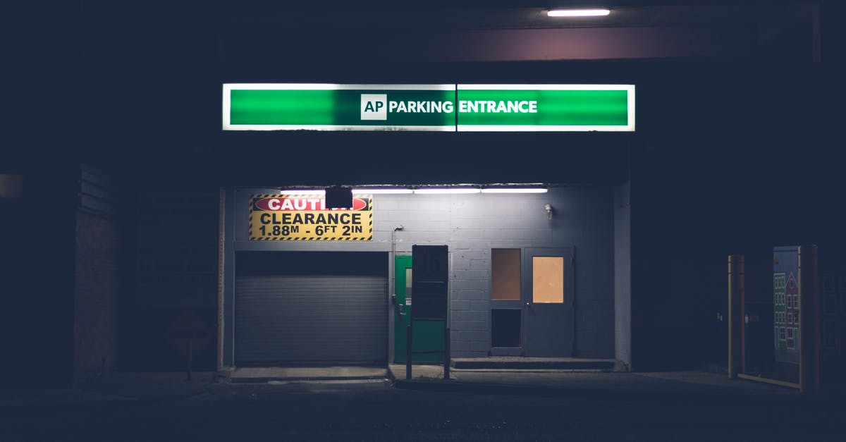 What would be my concourse and gate number for departure? - Building with PARKING ENTRANCE inscription in city at dusk What would be my concourse and gate number for departure? - Building with PARKING ENTRANCE inscription in city at dusk