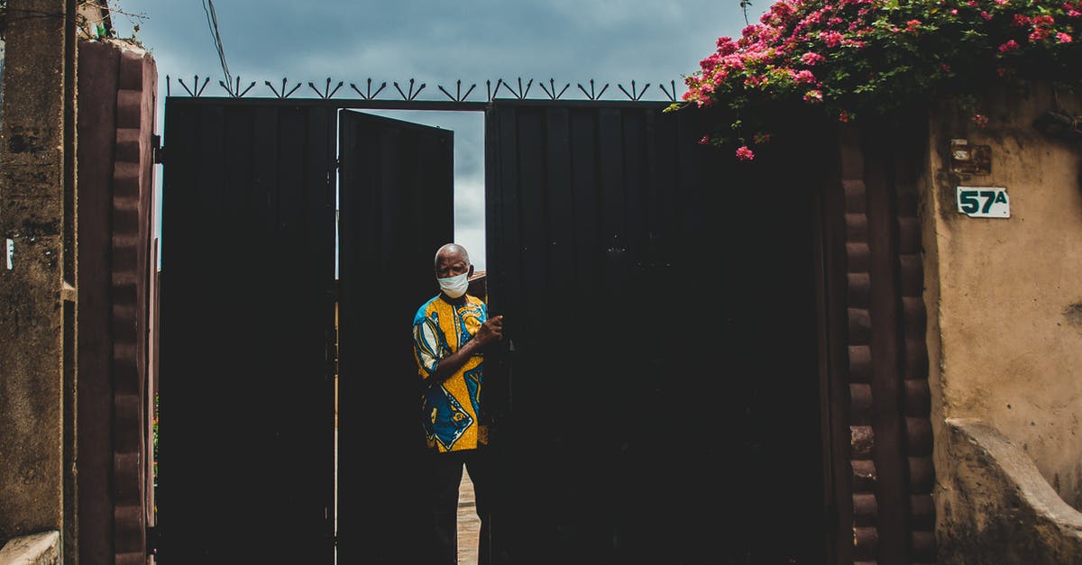 What would be my concourse and gate number for departure? - Anonymous ethnic male in colorful wear and mask standing near gate under cloudy sky during COVID 19 pandemic What would be my concourse and gate number for departure? - Anonymous ethnic male in colorful wear and mask standing near gate under cloudy sky during COVID 19 pandemic