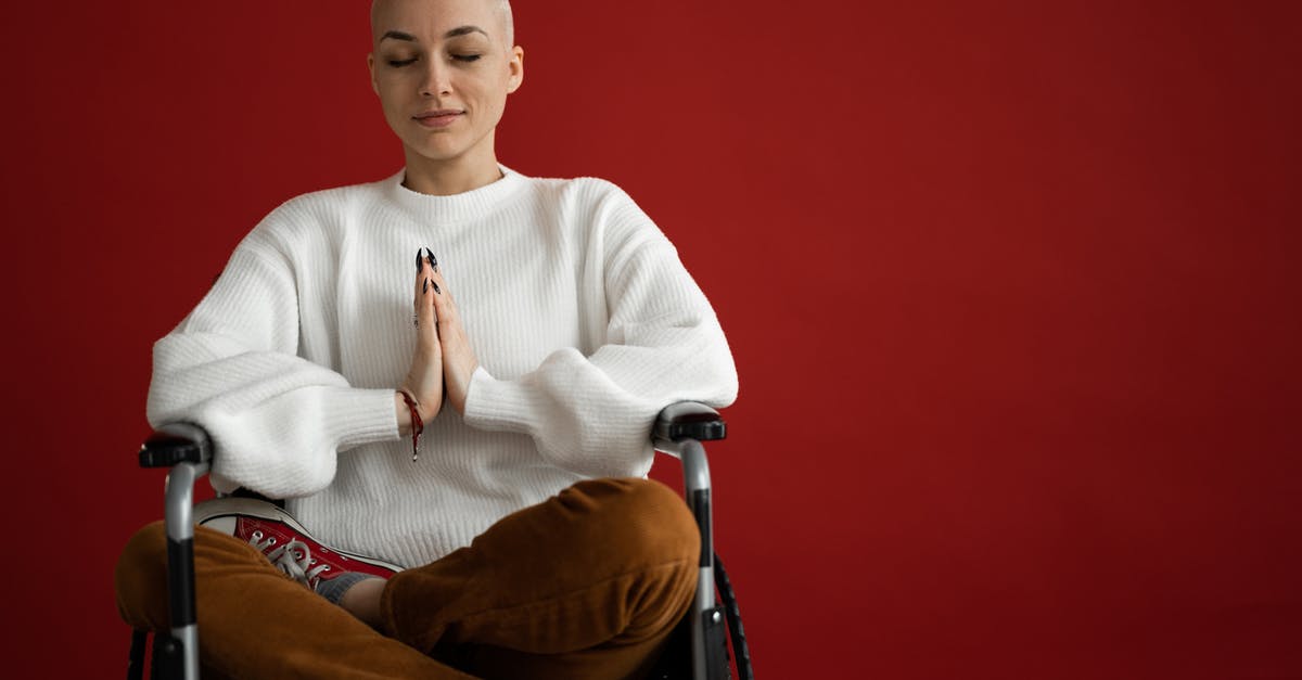 Wheelchair on a 15% slope [closed] - Young concentrated female with praying hands and crossed legs meditating during cancer recovery process on red background