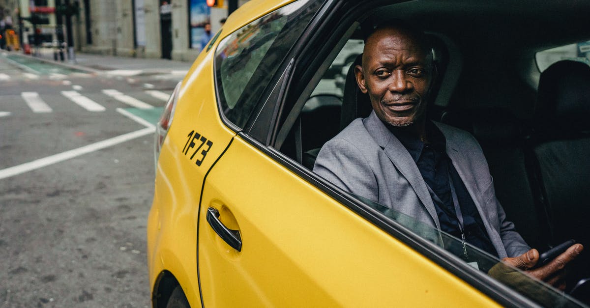 When changing trains when should one use the standalone yellow validitors? - Happy confident mature African American male looking away and expecting important message on mobile phone while sitting in yellow automobile When changing trains when should one use the standalone yellow validitors? - Happy confident mature African American male looking away and expecting important message on mobile phone while sitting in yellow automobile