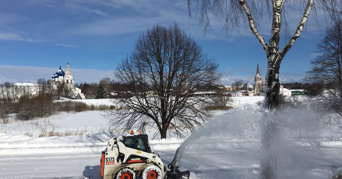 When driving in Belgium, what equipment is mandatory to have in a car registered in another country? - Scenery of modern snow cutter car driving along snowy road and cleaning surface in countryside on cold winter morning
