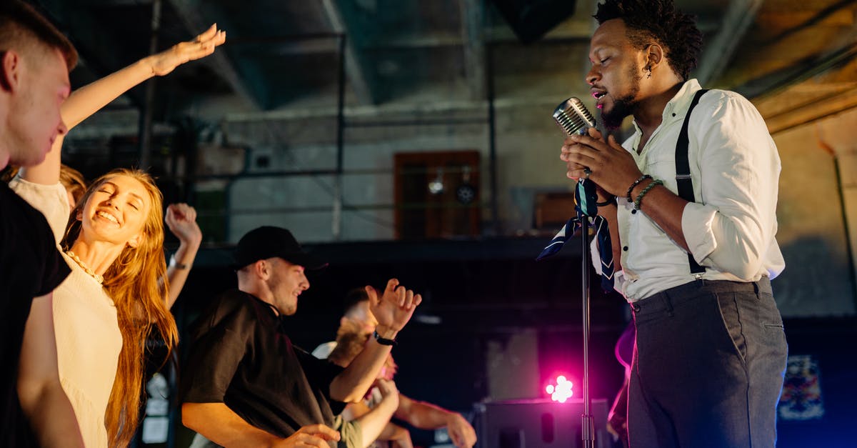 When is the best time to see live jazz in Europe? [closed] - Man in White Shirt Singing on Stage in Front of People