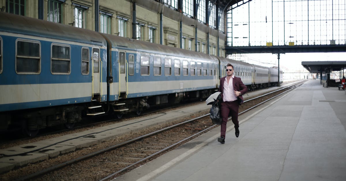 When the Edinburgh tram isn't running, is there an official alternative from the airport? - Man in a Purple Suit Running Beside Blue and White Train When the Edinburgh tram isn't running, is there an official alternative from the airport? - Man in a Purple Suit Running Beside Blue and White Train