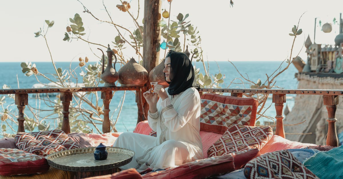 When travelling to China, does the Hijab have to be removed? - Woman in White Abaya And Black Hijab Sitting With View Of The Sea When travelling to China, does the Hijab have to be removed? - Woman in White Abaya And Black Hijab Sitting With View Of The Sea