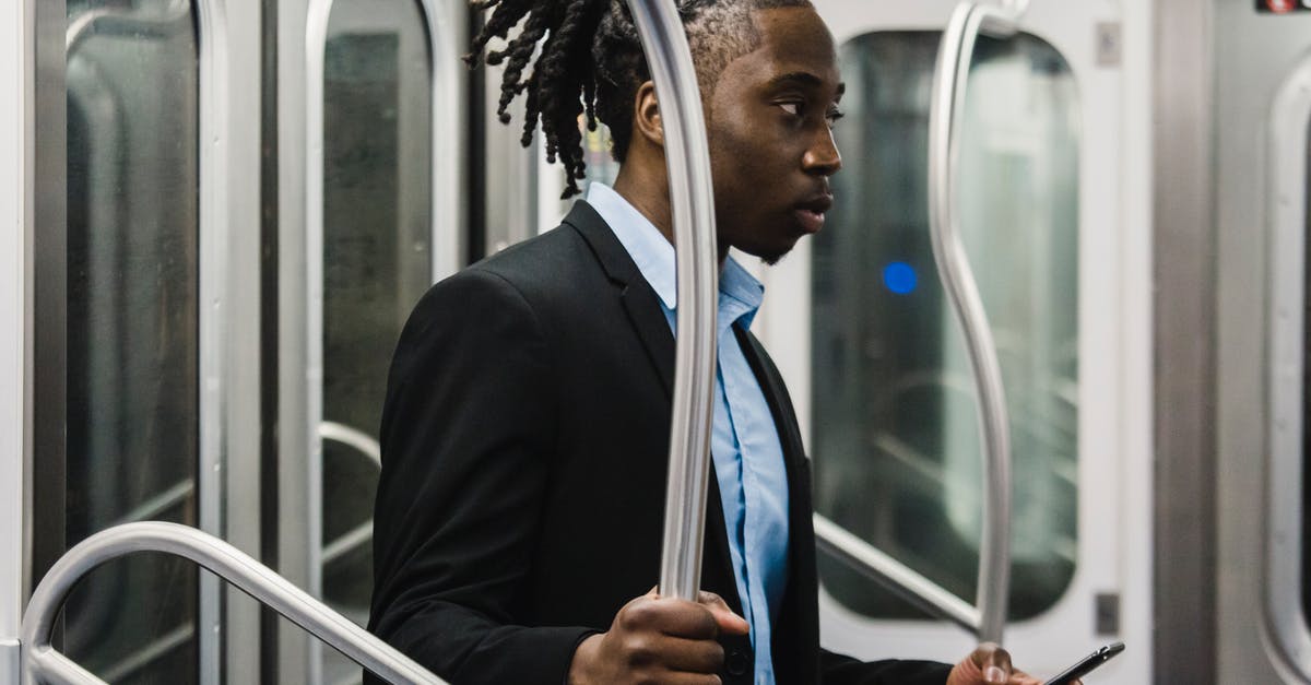 When using rail passes in Germany, can I use it in "urban trains" as well? (U-bahn, S-bahn) - Side view of young pensive African American male in formal wear with mobile in hand standing near grab rail while commuting home from work by metro train