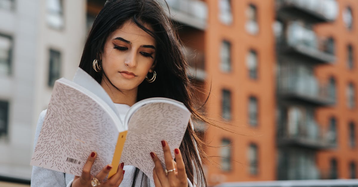 When visiting Istanbul, is pre-booking city tours from known web sites better than on arrival? - Focused ethnic woman reading magazine in city When visiting Istanbul, is pre-booking city tours from known web sites better than on arrival? - Focused ethnic woman reading magazine in city