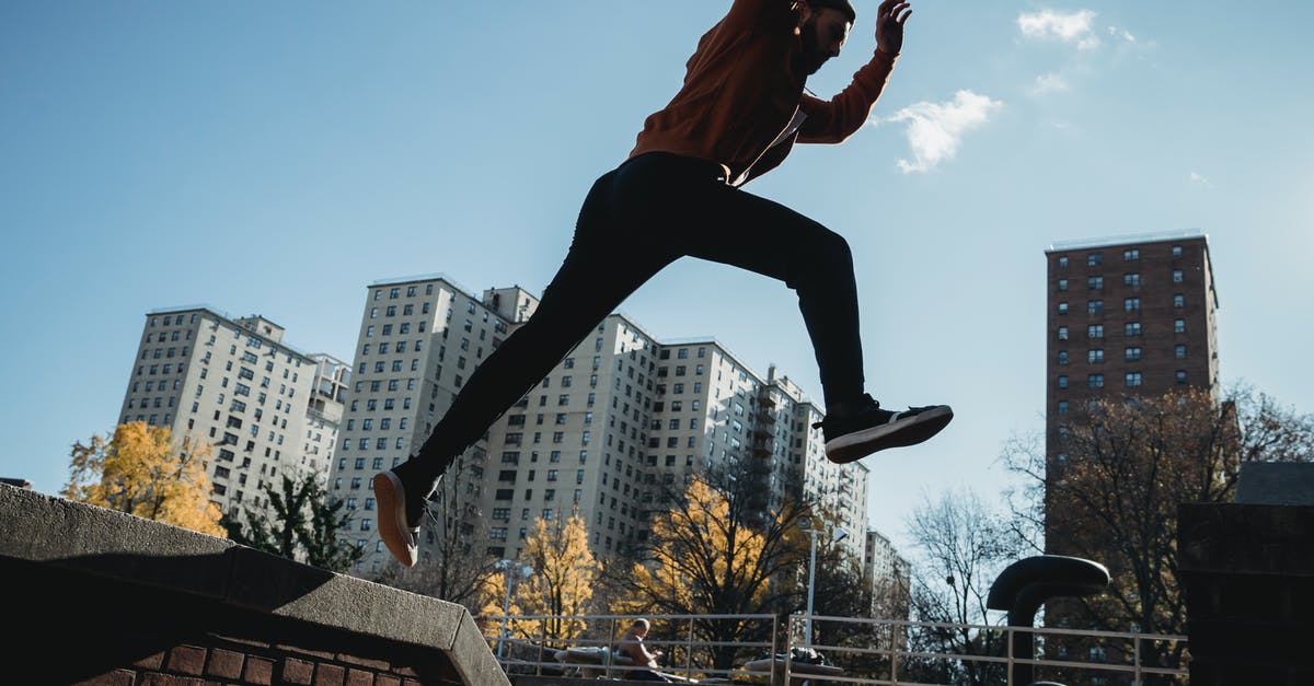 Where's the closest free parking for the Canadian side of Niagara Falls? - Side view energetic young male tracer in casual clothes jumping from brick fence against modern city buildings on clear sunny day Where's the closest free parking for the Canadian side of Niagara Falls? - Side view energetic young male tracer in casual clothes jumping from brick fence against modern city buildings on clear sunny day