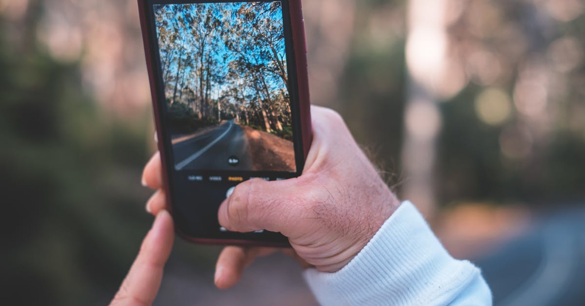 Where's this picture of a glacial moraine in autumn taken? - Crop unrecognizable man taking photo of rural road Where's this picture of a glacial moraine in autumn taken? - Crop unrecognizable man taking photo of rural road