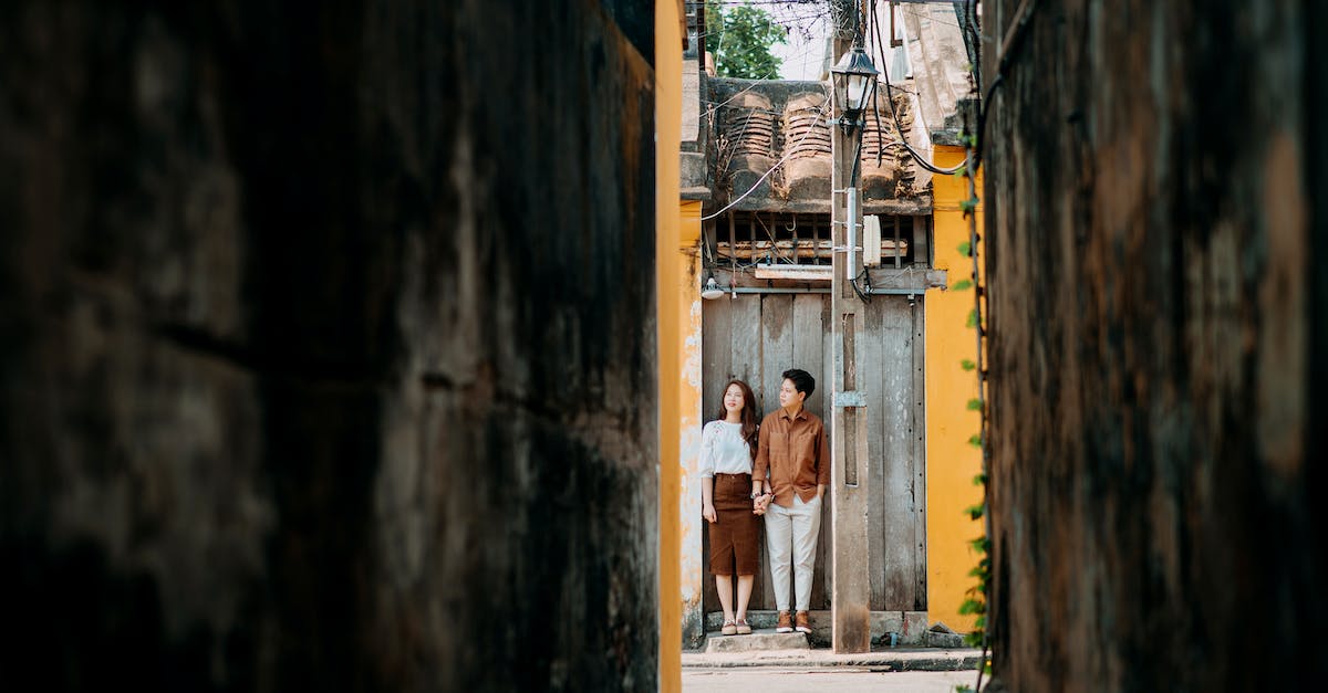 Where can a middle-aged couple move for a couple of years working holiday and travel base? [closed] - Stylish ethnic couple holding hands near old small house